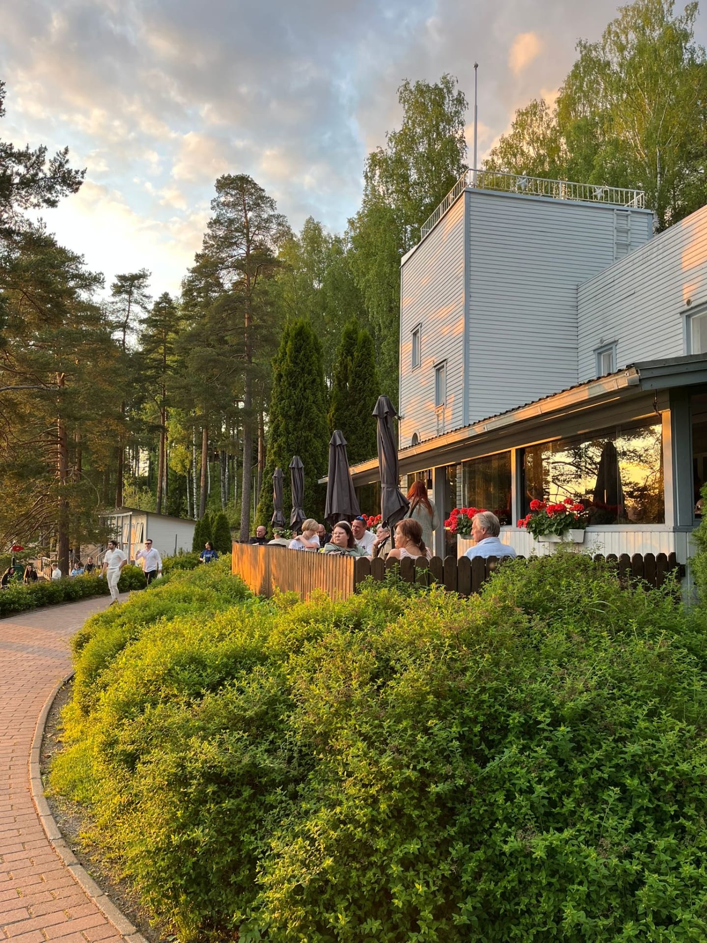 A white funky-style building with a glazed terrace in the foreground.
