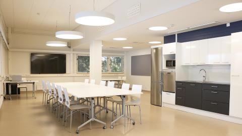 Monitoimitila Vierashuone kalustettuna tuoleilla ja pöydillä