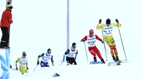 SM-hiihdot 2022 Hiihtäjiä ladulla. lapsi on kiivennyt korokkeelle seuraamaan kilpailua.